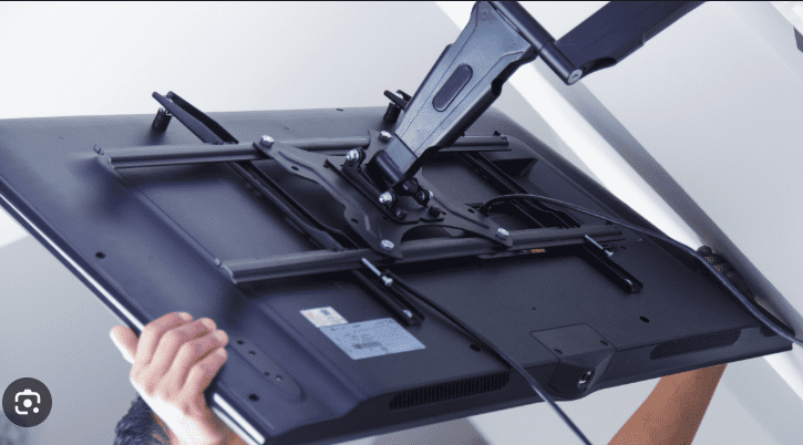 TV uninstallation service technician removing wall mounted television safely